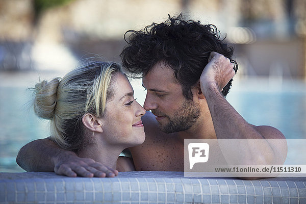 Zärtliches Paar  das sich gemeinsam im Pool entspannt.