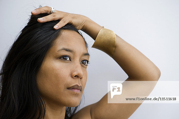 Woman looking away in thought with hand on head  portrait