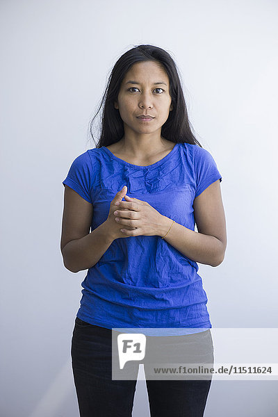Woman standing with clasped hands  portrait