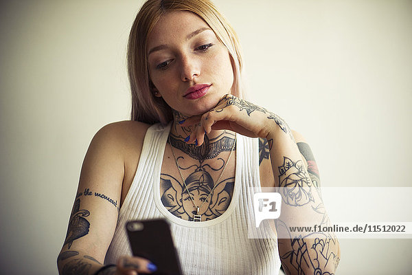 Tattooed woman using smartphone