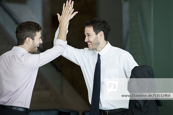 Business colleagues exchanging high five