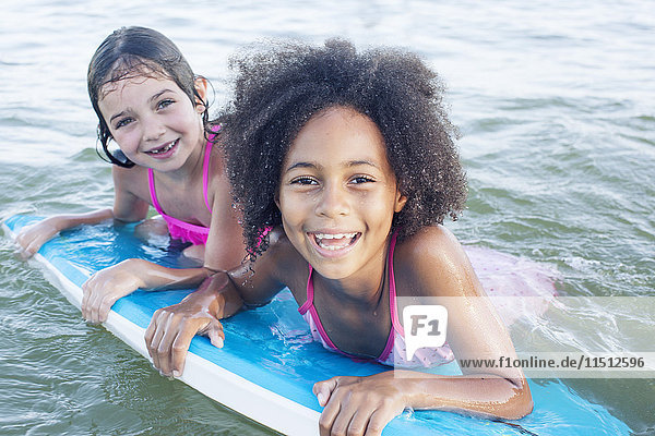 Mädchen schweben auf dem Bodyboard im Wasser