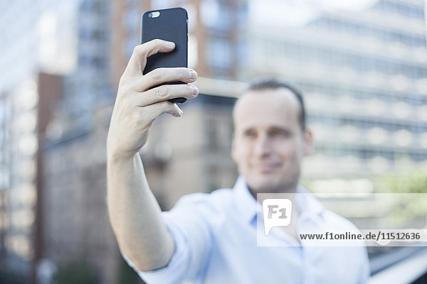 Man using smartphone to take a selfie