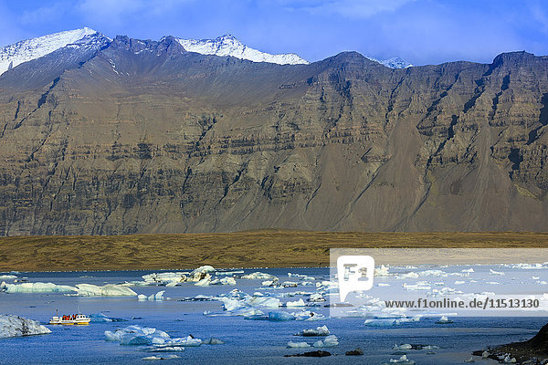 Touristenboot in Eisbergen auf dem Gletschersee Jokulsarlon im Vatnajokull-Nationalpark im Südosten Islands  Polarregionen