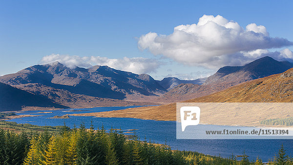 The road to the Scottish Highlands passing Loch Loyne and the distant mountains Scotland United Kingdom Europe