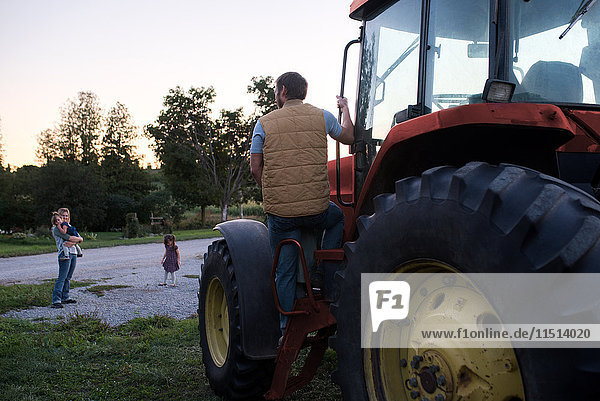 Familie auf dem Bauernhof  Vater steigt in den Traktor