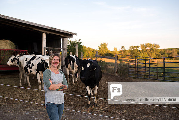Porträt einer Bäuerin auf dem Bauernhof  Kühe im Hintergrund
