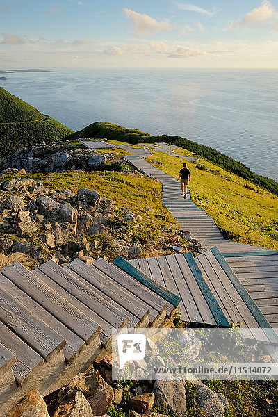 Man on wooden steps by sea  Cape Breton  Nova Scotia  Canada