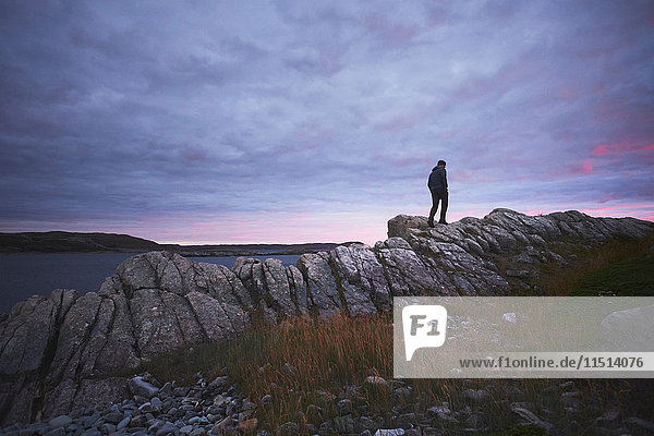 Hiker hiking on rocks at dusk  Fogo Island  Newfoundland  Canada