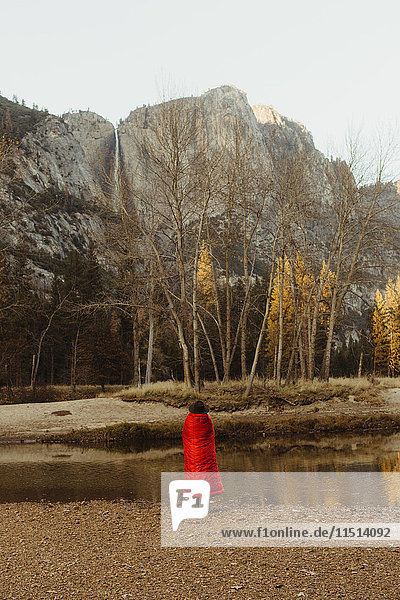 Rückansicht einer in eine rote Decke gehüllten Frau mit Blick auf den Berg  Yosemite National Park  Kalifornien  USA