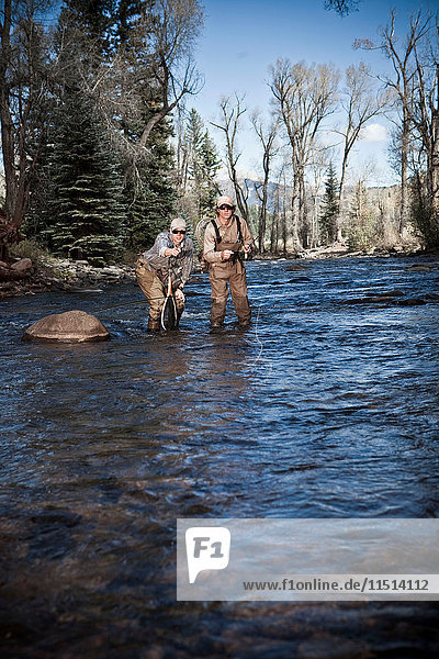 Fishermen ankle deep in river fly fishing  Colorado  USA