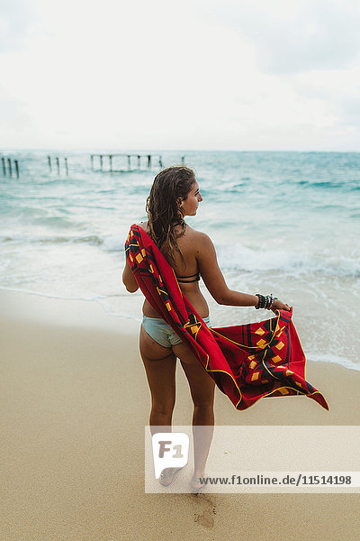 Rückansicht einer Frau am Strand  die sich mit einem Handtuch abtrocknet  Oahu  Hawaii  USA
