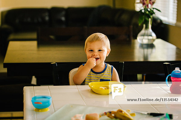Junge Junge isst Essen am Tisch
