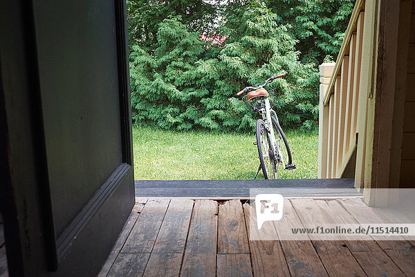 Offene Haustür mit Fahrrad im Garten