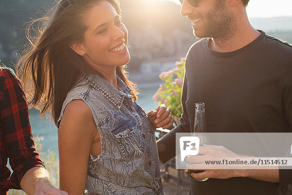 Young couple drinking beer at waterfront party  Budapest  Hungary