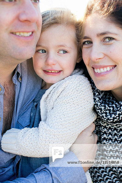 Close up portrait of mid adult couple and daughter