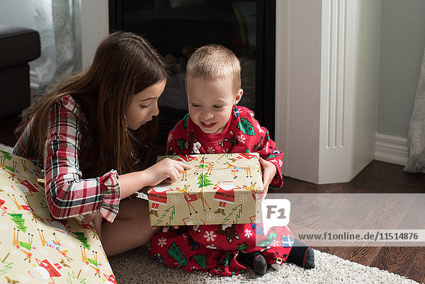 Bruder und Schwester öffnen Weihnachtsgeschenk