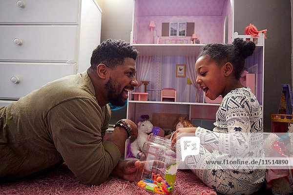 Vater und Tochter spielen an ihrem Puppenhaus