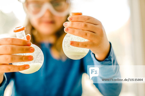 Mädchen macht wissenschaftliches Experiment  hält Flüssigkeitskolben