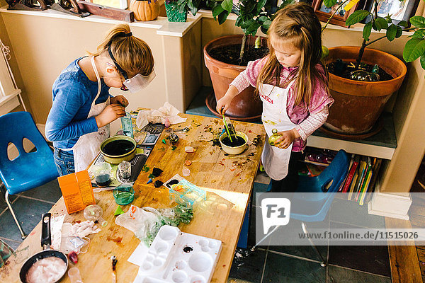 Two girls doing science experiments at messy table