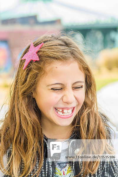 Bildnis eines Mädchens mit langem braunem gewelltem Haar beim Lachen