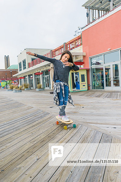 Girl skateboarding on boardwalk