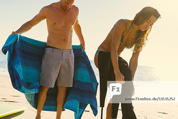 Surferpaar zieht Neoprenanzug an Newport Beach  Kalifornien  USA  an