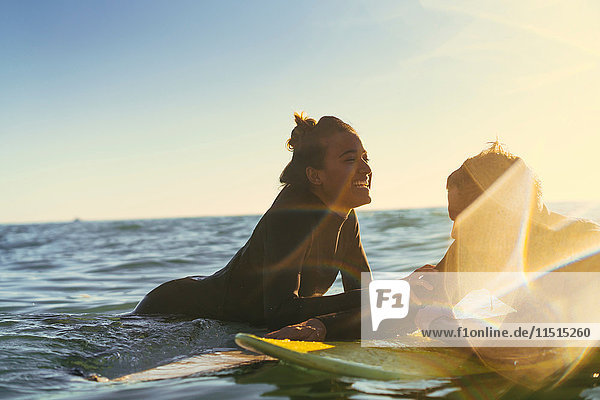 Surferpaar  das sich auf Surfbrettern im Meer anlehnt  Newport Beach  Kalifornien  USA