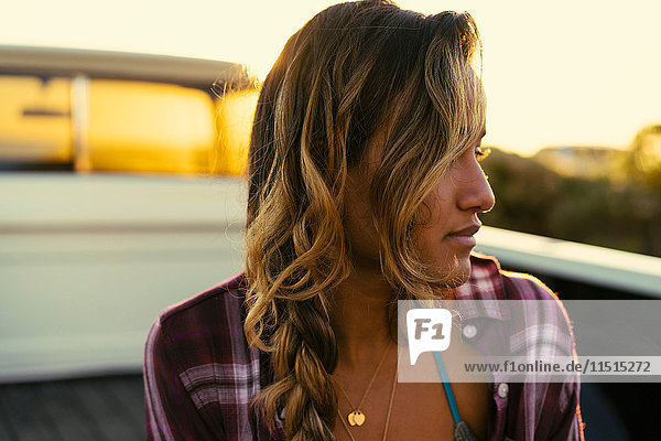 Young woman looking sideways from back of pickup truck at Newport Beach  California  USA