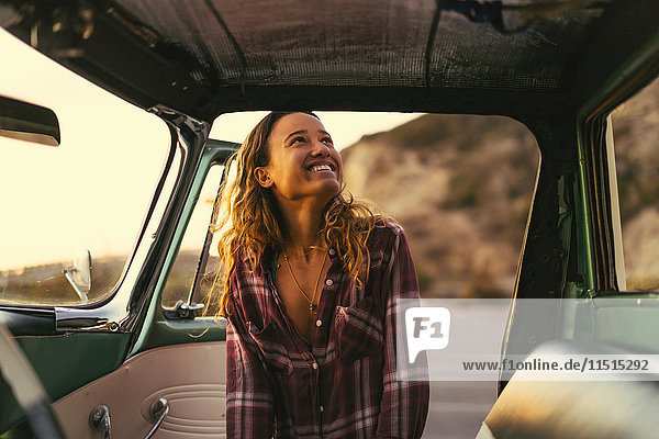 Happy young woman at pickup truck door at Newport Beach  California  USA