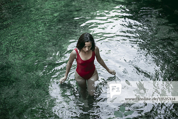 Kaukasische Frau watet in einem Wasserbecken
