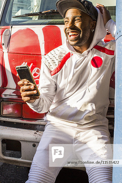 Lachender Schwarzer  der für ein Selfie mit seinem Handy posiert