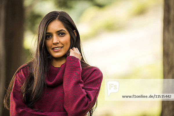 Porträt einer lächelnden indischen Frau mit Pullover