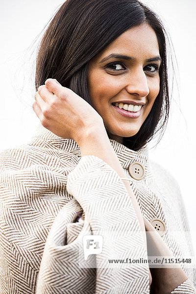 Portrait of smiling Indian woman wearing coat