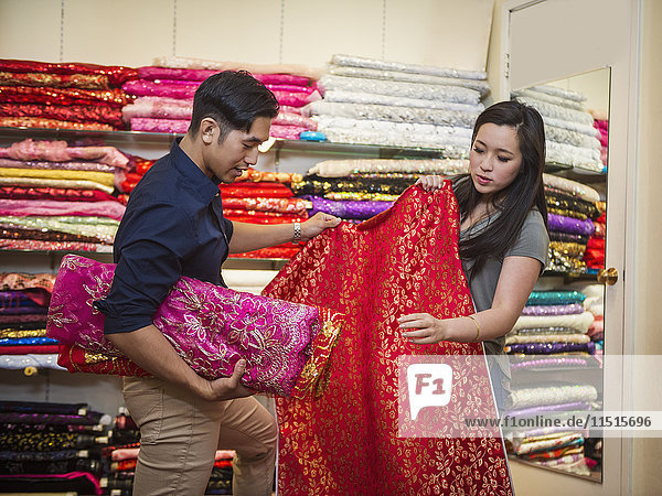 Chinesischer Mann und Frau beim Einkaufen von Stoffen