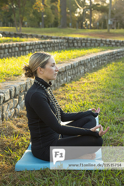 Caucasian woman meditating in park