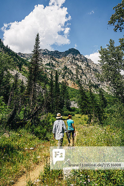 Caucasian couple hiking on path in mountains