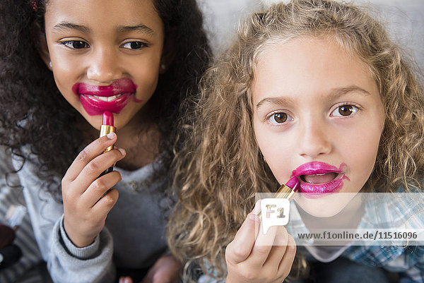 Girls applying messy lipstick