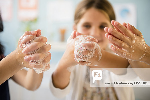 Mädchen waschen sich die Hände mit Seife