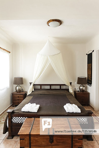 Chest near wooden bed in bedroom