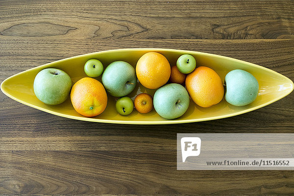 Bowl with fruit on wooden table