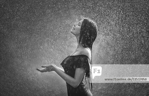 Lächelnde kaukasische Frau im Regen stehend