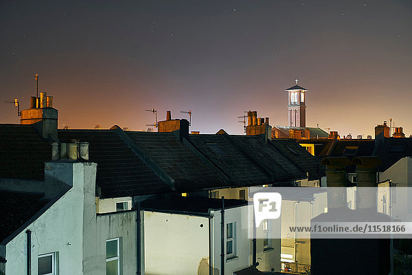 Erhöhter Blick auf Reihenhausdächer und Glockenturm bei Nacht  Brighton  East Sussex  England