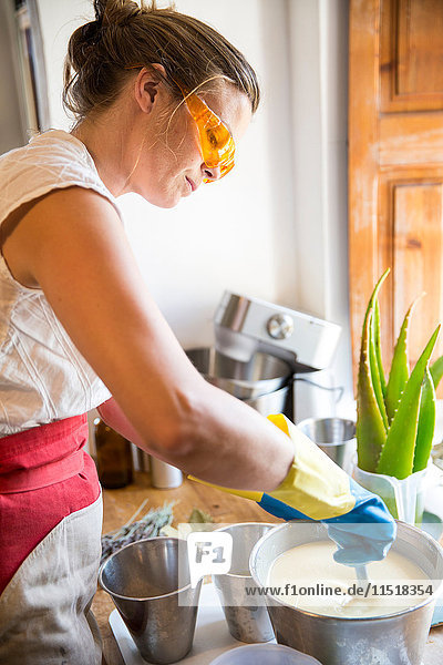 Mittelteil einer Frau Rührschüssel mit flüssiger Lavendelseife in einer Werkstatt für handgemachte Seife