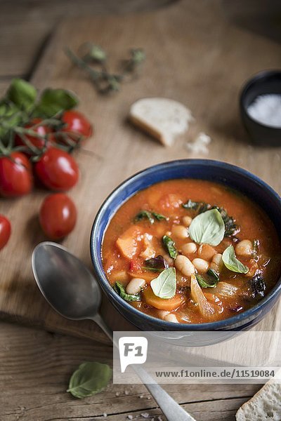 Toskanische Ribollita-Suppe mit Bohnen  Tomaten  Grünkohl und Basilikum in einer Schüssel