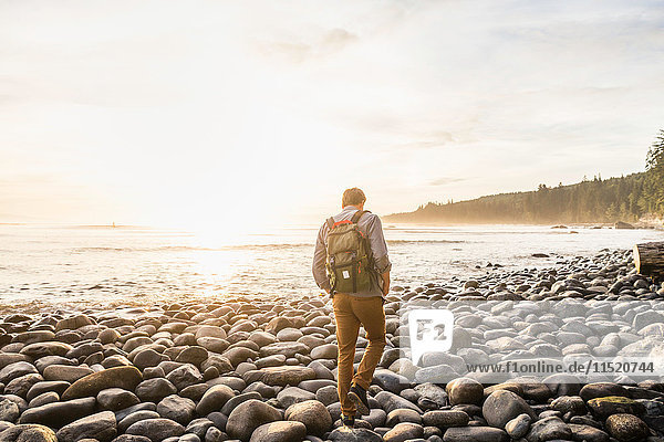 Rear view of man walking on beach in Juan de Fuca Provincial Park Vancouver Island British Columbia Canada