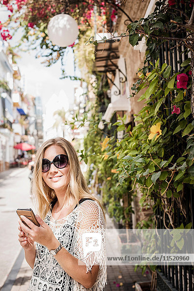 Frau auf der Straße schaut lächelnd in die Kamera  Altstadt von Marbella  Spanien