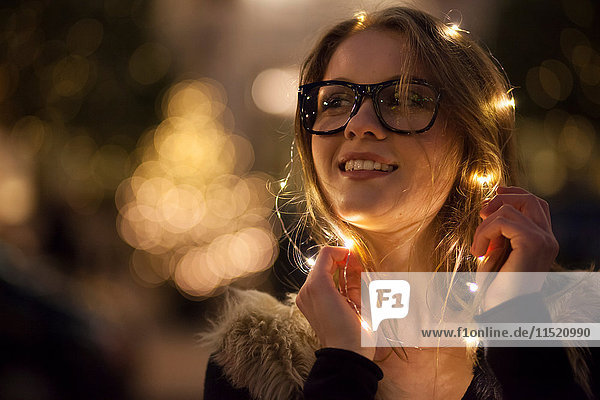 Young woman with garland of lights around her face