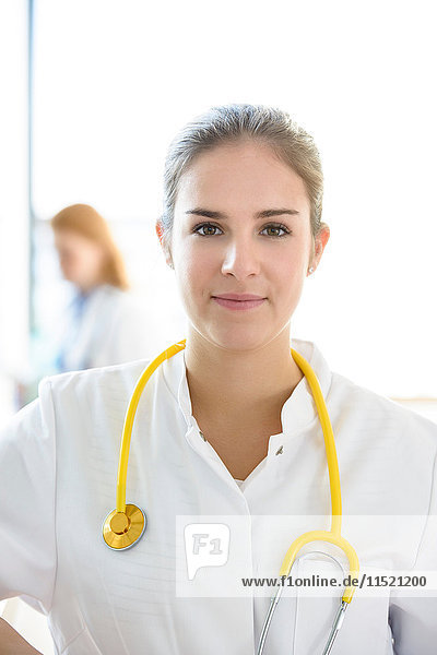 Porträt einer jungen Ärztin mit gelbem Stethoskop