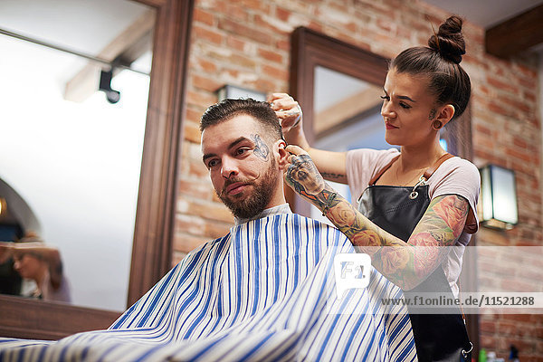 Friseur schneidet den Kunden die Haare